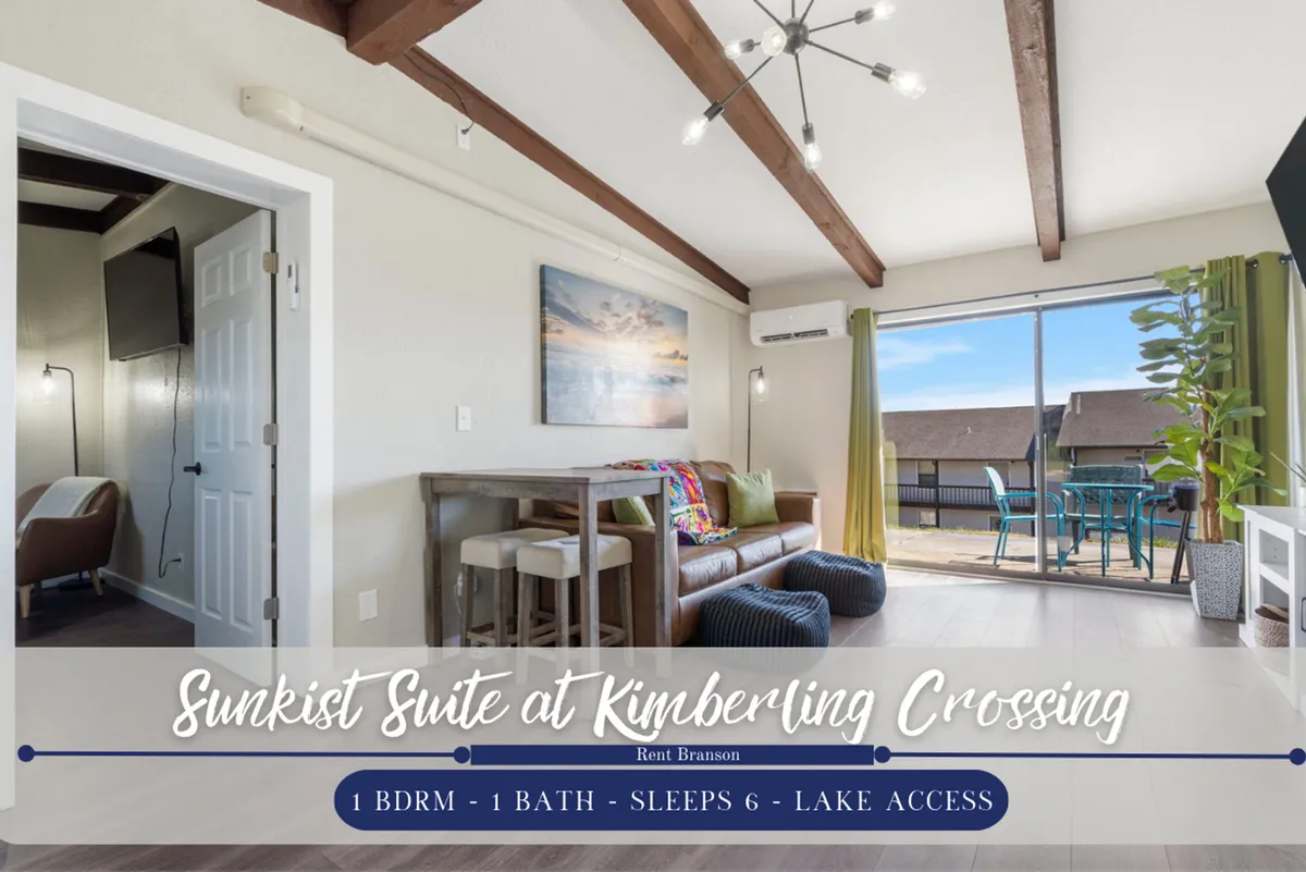 The image showcases a cozy, sunlit living and dining area in a condo, featuring a comfortable sofa and a dining table situated near a large window that frames gorgeous views of Table Rock Lake. Artwork adds warmth to the walls, and the overall space feels inviting and perfect for relaxation or family gatherings.