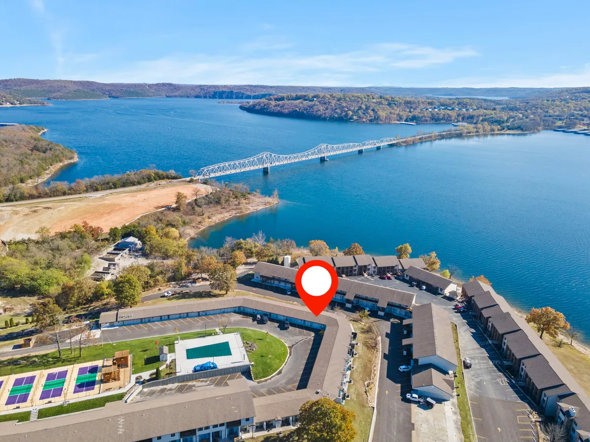 A tranquil lake scene featuring a bridge, a swimming pool, and lush trees. The space offers opportunities for boating, fishing, and swimming, with a relaxing ambiance perfect for outdoor adventures close to nature.